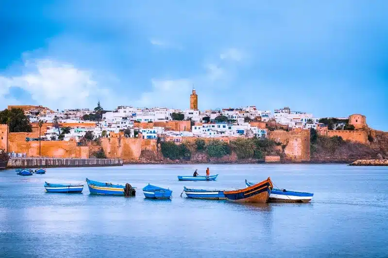 Fishing boats bobbing in the water near a town in Morocco, showcasing local maritime life and scenic views.