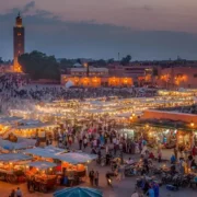 A panoramic view of a Moroccan city nestled in the desert, showcasing traditional architecture against a sandy landscape.
