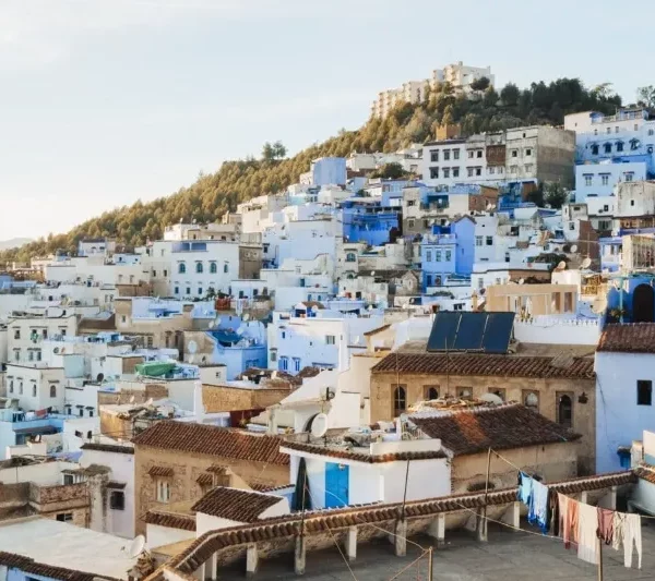 Scenic view of Chefchaouen, Morocco, showcasing its iconic blue buildings and mountainous backdrop during a visit.