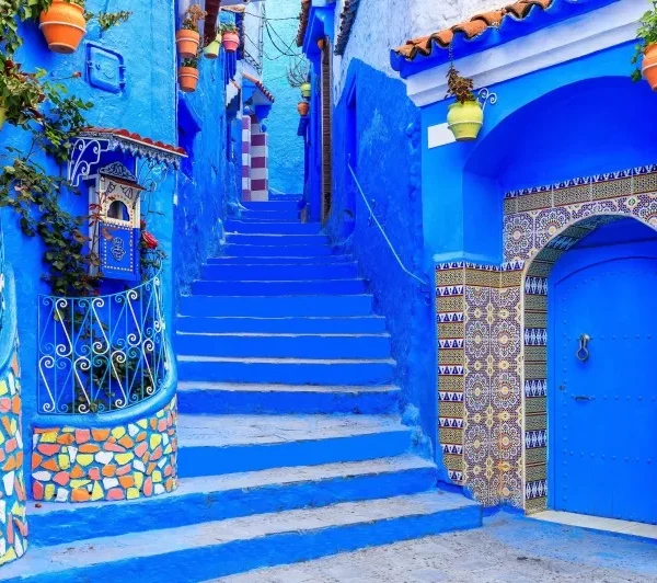 Scenic view of Chefchaouen, Morocco, showcasing its iconic blue buildings and mountainous backdrop during a visit.