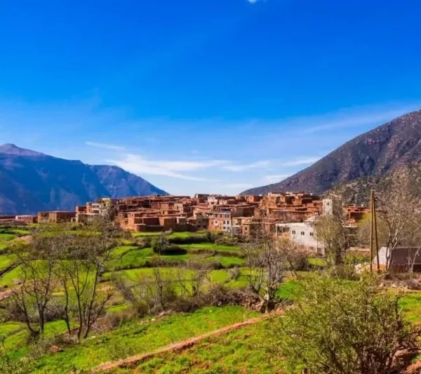 A scenic view of the village of Atlas in Morocco, showcasing traditional architecture against a mountainous backdrop.