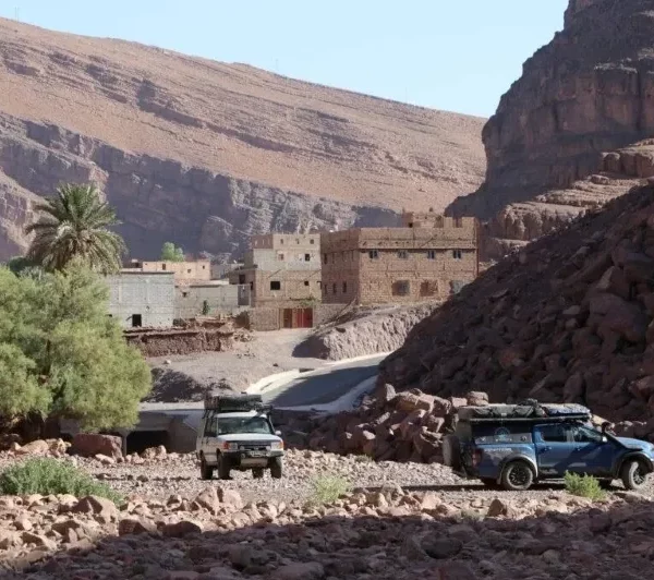 Two jeeps parked in front of a mountain village, showcasing the scenic landscape during 4 Days Agadir.