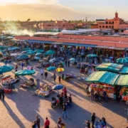 A bustling market in Marrakech, Morocco, filled with colorful stalls and shoppers exploring local goods and crafts.