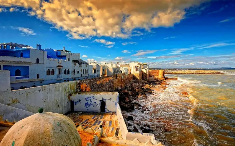 Scenic view of Chefchaouen, Morocco, featuring its iconic blue and white buildings against a mountainous backdrop.