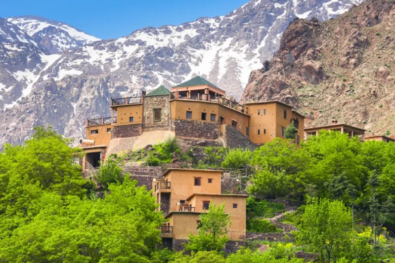 A stunning building nestled in the mountains, with a majestic mountain range visible in the background.
