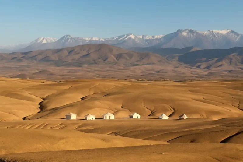 A vast desert landscape featuring several tents, representing Marrakech Desert Tours.