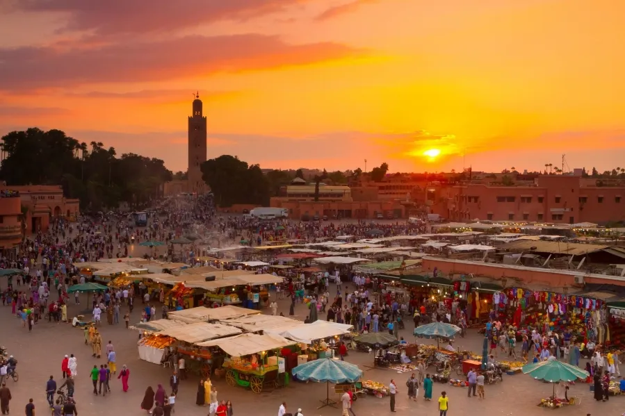Sunset over Marrakech, Morocco, showcasing vibrant colors in the sky, reflecting the warm weather of the region.
