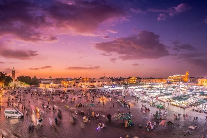 Dusk in Marrakech, Morocco, with the city skyline aglow and the sky painted in warm hues of sunset.