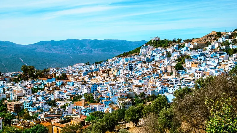 Scenic view of Chefchaouen, Morocco, showcasing its iconic blue buildings and mountainous backdrop.