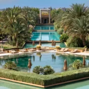 A serene pool surrounded by lush palm trees, set within a luxurious resort in Marrakech.