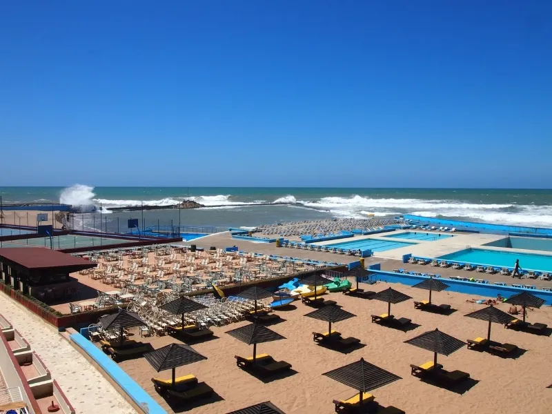 A panoramic view of the beach and pool area from a building, showcasing the vibrant scenery of Casablanca day tours.