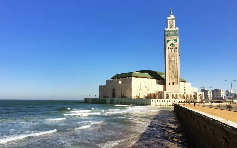 A large white building with a green tower, featured in Casablanca day tours, showcasing local architecture.