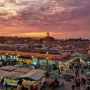 Sunset casting warm hues over the skyline of Marrakech, highlighting the city's unique architecture and vibrant atmosphere.