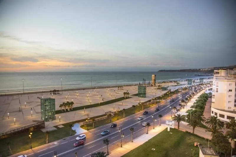 A scenic view of a beach and the sea from a balcony, showcasing Morocco's coastal beauty in August.