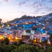 A scenic view of Chefchaouen, Morocco, showcasing its iconic blue buildings and mountainous backdrop.
