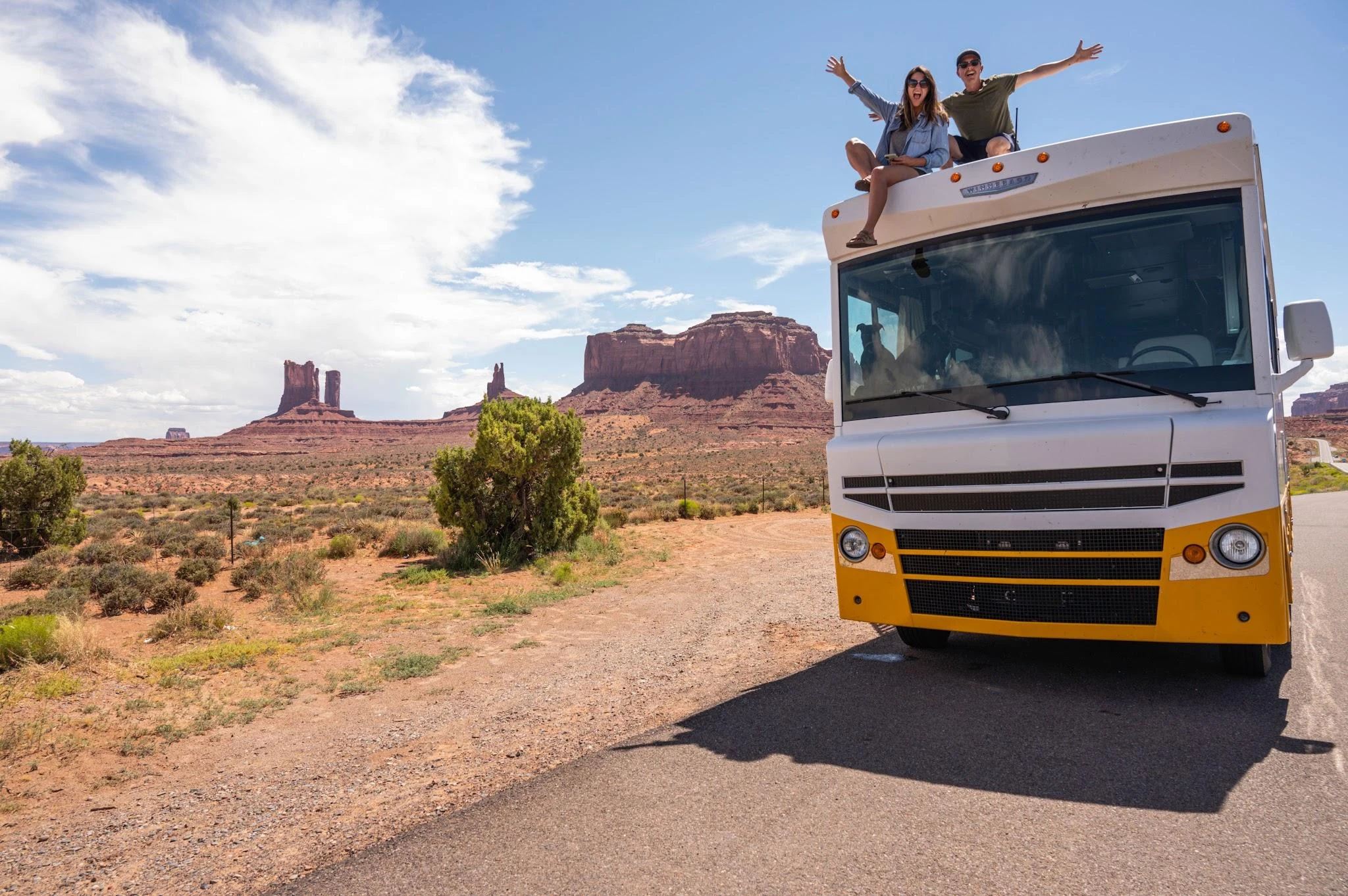 Couple Sitting on Top of Campervan RV in Morocco Desert