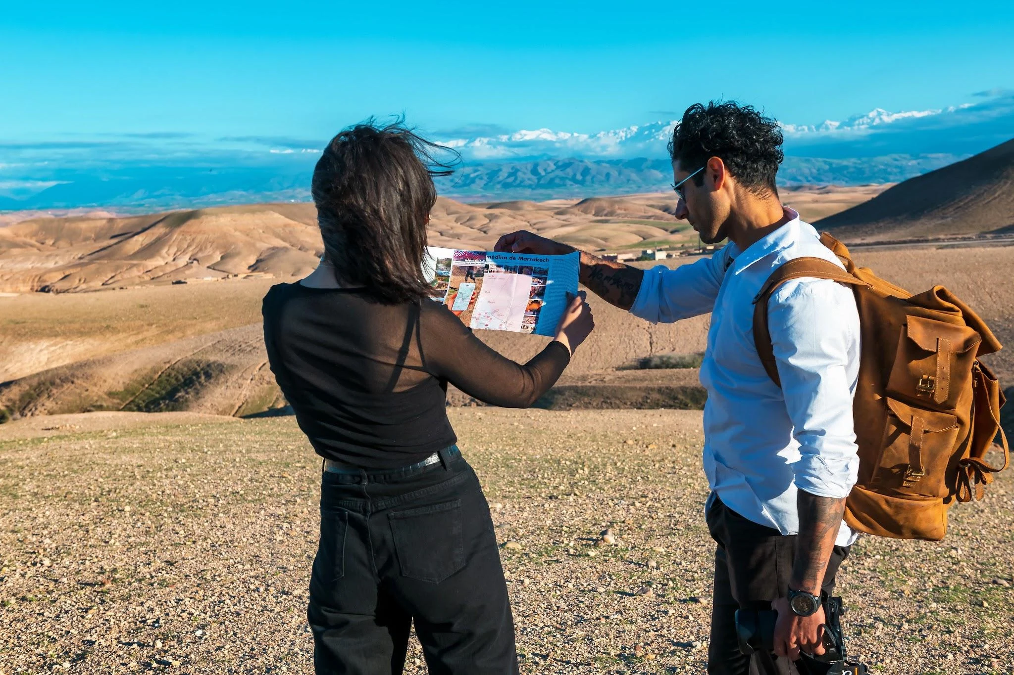 Explorers with map planning a desert RV trip in Morocco